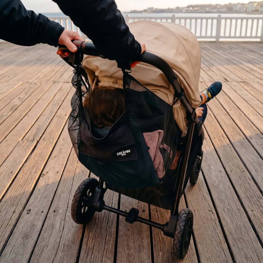 Enfant assis dans le hamac Dreamini avec filet de protection installé