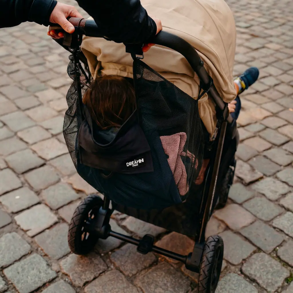 Enfant assis dans le hamac Dreamini avec filet de protection installé